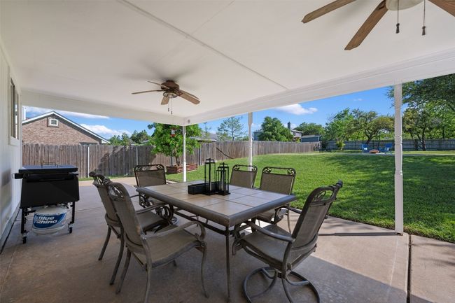 View of patio featuring a ceiling fan, area for grilling, a fenced backyard, and outdoor dining area | Image 30