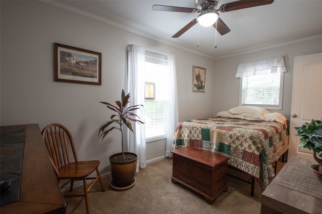 Second Bedroom featuring light carpet, ceiling fan, crown molding, and baseboards when furnished. | Image 34