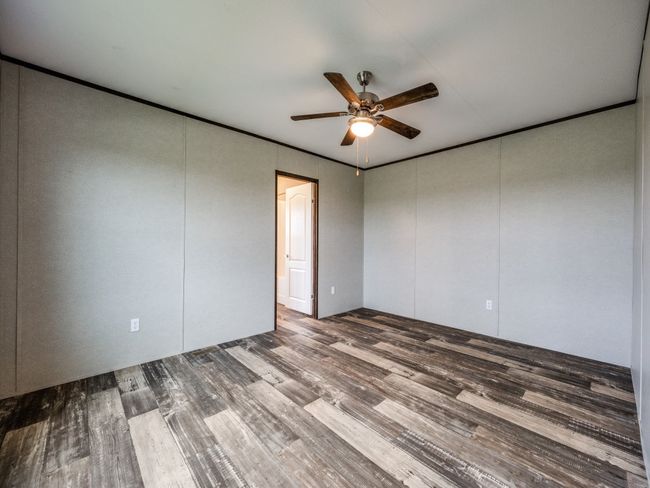 Spare room featuring a ceiling fan, crown molding, and wood finished floors | Image 11