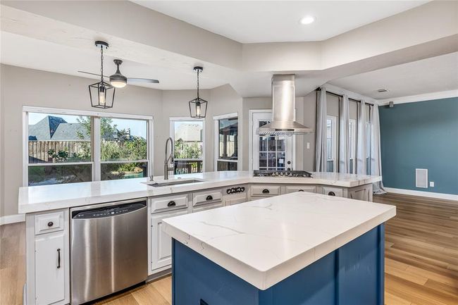 Remodeled kitchen with quartz countertops and a stylish pop of color on the island cabinets | Image 16