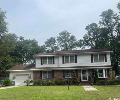 View of front property with a garage and a front lawn | Image 1