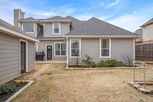 Back of house featuring roof with shingles, a lawn, a patio area, and fence | Image 27