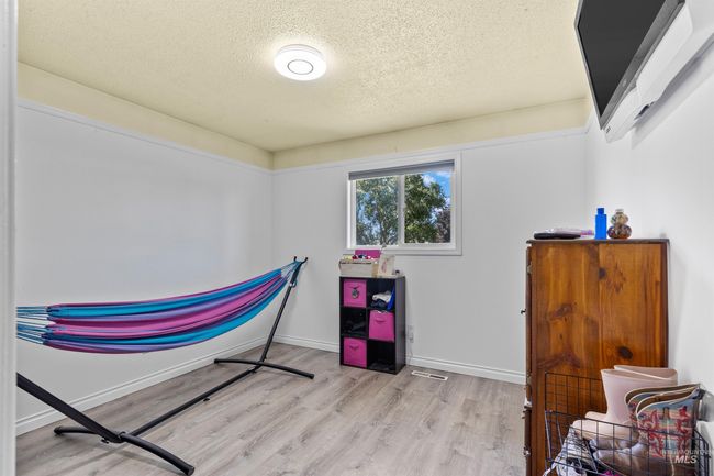 Bedroom with a textured ceiling and wood finished floors | Image 19