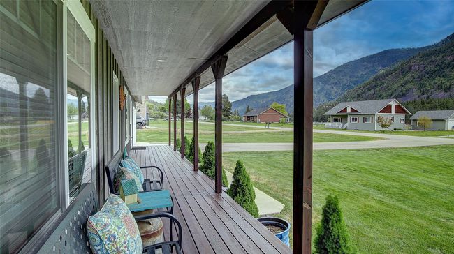 Porch featuring a mountain view, a yard, and a residential view | Image 60