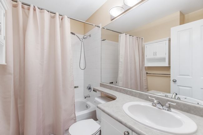 Bathroom featuring shower / bath combo with shower curtain, vanity, and toilet | Image 26