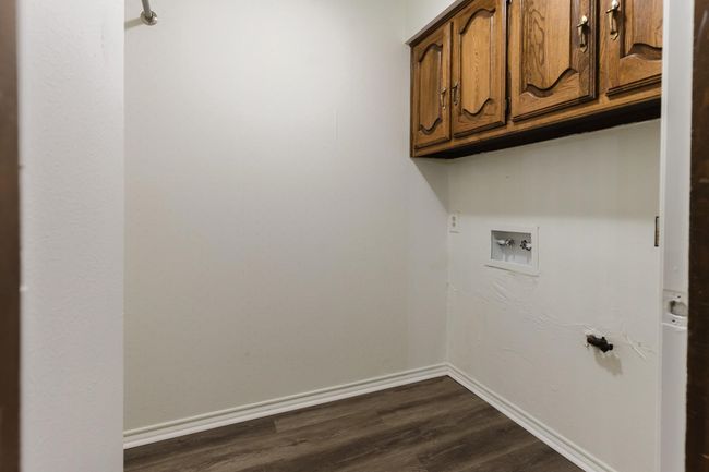 Laundry area featuring dark wood-style floors, cabinet space, baseboards, and hookup for a washing machine | Image 25