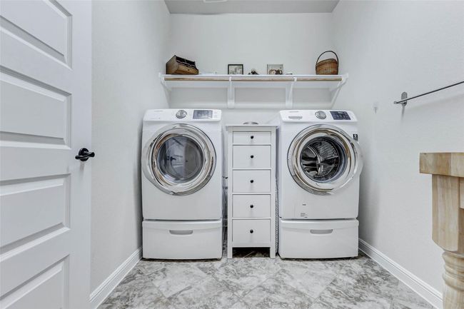 The spacious laundry roomprovides ample room for yourwasher and dryer, complete withopen shelving and a convenienthanging rack. | Image 22