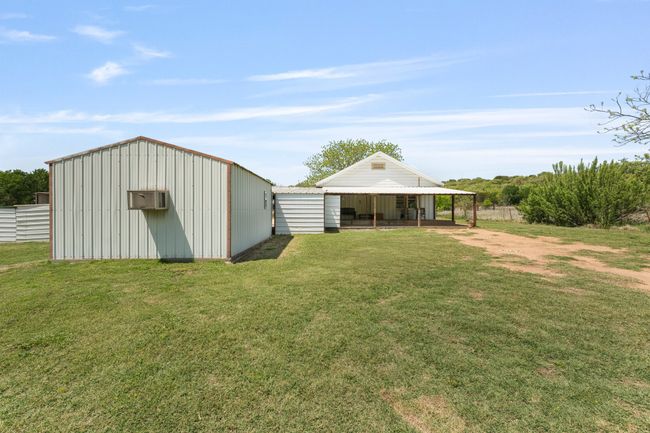 View of yard featuring fence, an outbuilding, a wall mounted air conditioner, and a pole building | Image 22