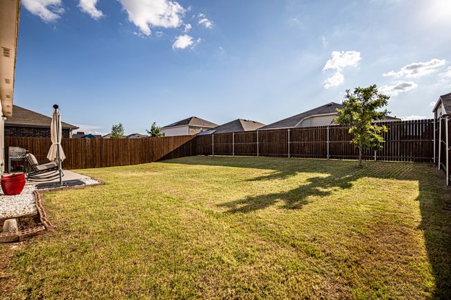 Fenced backyard with a patio area | Image 29