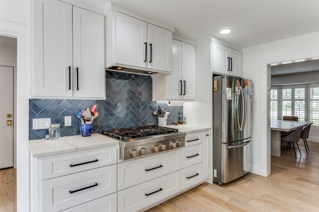 6 burner gas cooktop with tile backsplash and quartz counters. Terrific storage drawers. | Image 7