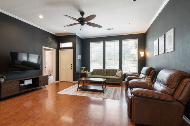Living area with wood finished floors, a ceiling fan, recessed lighting, and crown molding | Image 5