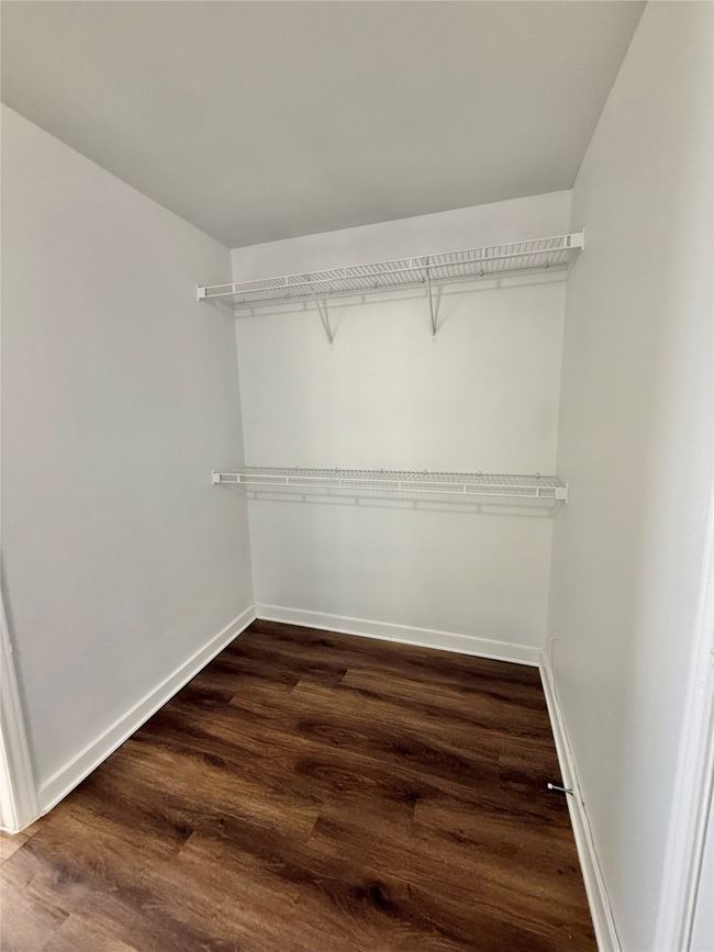 Walk in closet featuring dark wood-style flooring | Image 14