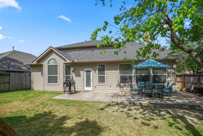 Looking back at the home from near the back fence, you’ll appreciate the spacious yard surrounded by mature shade trees, providing a serene and private setting. | Image 33