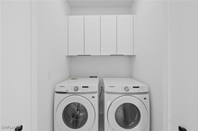 Laundry room with washing machine and clothes dryer and cabinet space | Image 18
