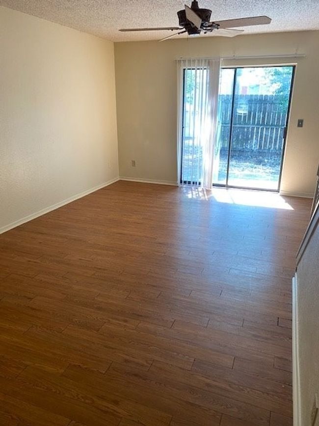 Spare room with dark wood-type flooring, a textured ceiling, ceiling fan, and baseboards | Image 5