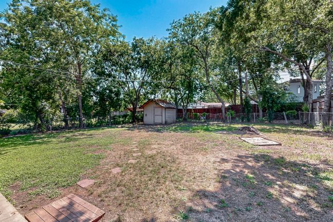 Fenced backyard with a storage unit | Image 31