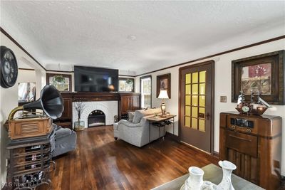 Living room featuring dark wood-type flooring, a fireplace, and a textured ceiling | Image 3