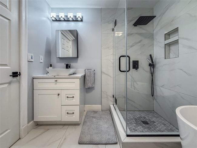 Full bathroom featuring marble finish floors, a marble finish shower, vanity, radiator, and a soaking tub | Image 24