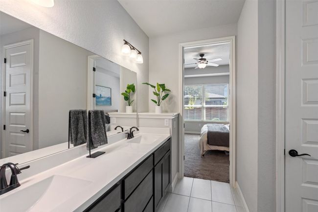 Full bath featuring double vanity, tile patterned floors, ensuite bath, and a ceiling fan | Image 22