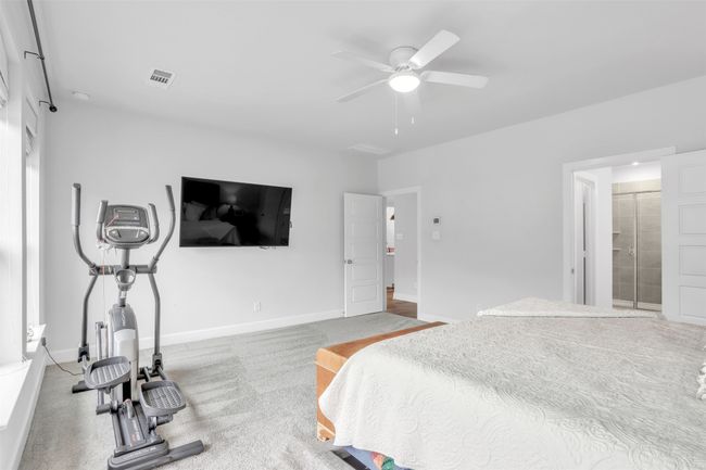 Carpeted bedroom with connected bathroom and ceiling fan | Image 17