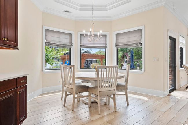 Dining space with a chandelier, light wood-style floors, baseboards, and ornamental molding | Image 11