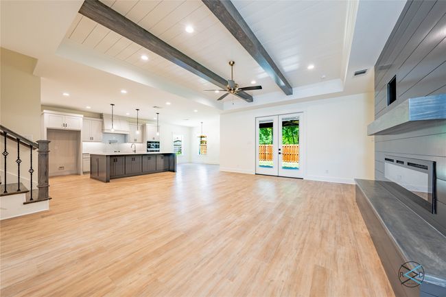 Living room with light hardwood / wood-style flooring, ceiling fan, a fireplace, french doors, and beamed ceiling | Image 8