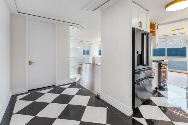 Kitchen with premium appliances, white cabinetry, and open shelves | Image 11