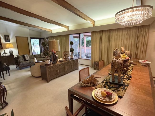 Living area featuring a chandelier, beam ceiling, and light colored carpet | Image 23