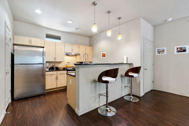 Kitchen with appliances with stainless steel finishes, under cabinet range hood, dark countertops, dark wood-type flooring, and recessed lighting | Image 8