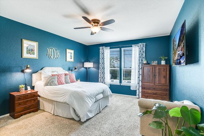 Bedroom featuring carpet, baseboards, a textured wall, and a ceiling fan | Image 13