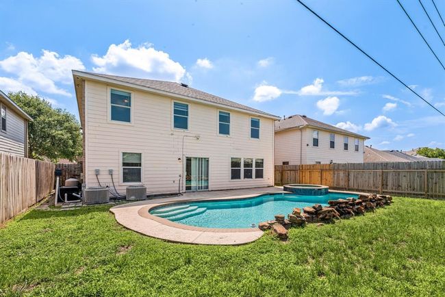Unwind after a long day in this beautifully designed backyard with a crystal-clear pool, spa, and fully fenced yard for added privacy. | Image 20