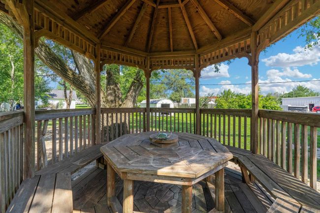 Wooden terrace with a gazebo, a lawn, and outdoor dining space | Image 33