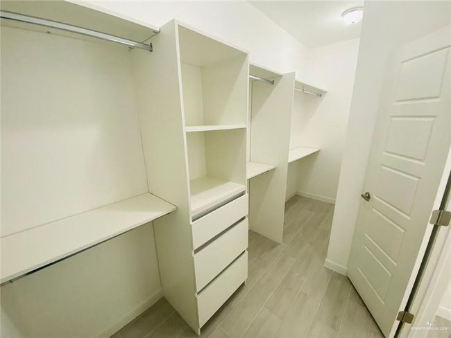 Walk in closet with light wood finished floors | Image 8