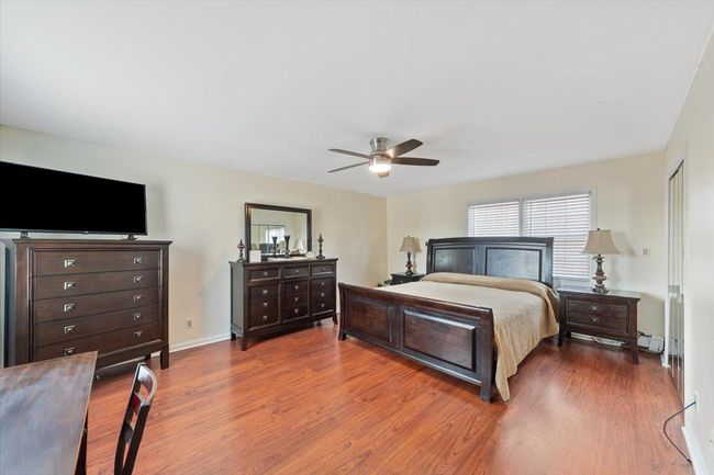 Bedroom with AC featuring baseboards, wood finished floors, and a ceiling fan | Image 15