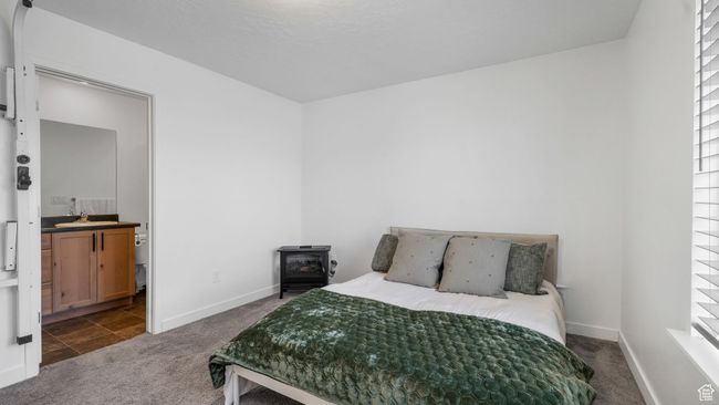 Bedroom featuring a wood stove and dark carpet | Image 20