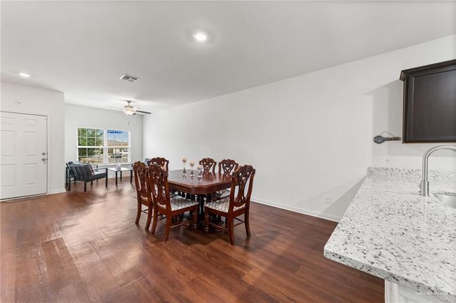 Dining space featuring dark wood finished floors, a ceiling fan, recessed lighting, and baseboards | Image 4
