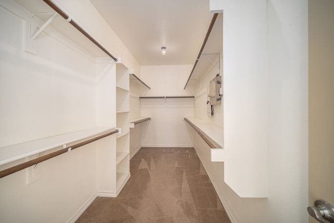 Walk in closet with dark carpet | Image 34
