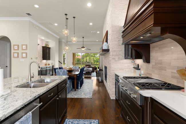 Kitchen featuring a sink, stainless steel appliances, ceiling fan, ornamental molding, and backsplash | Image 8