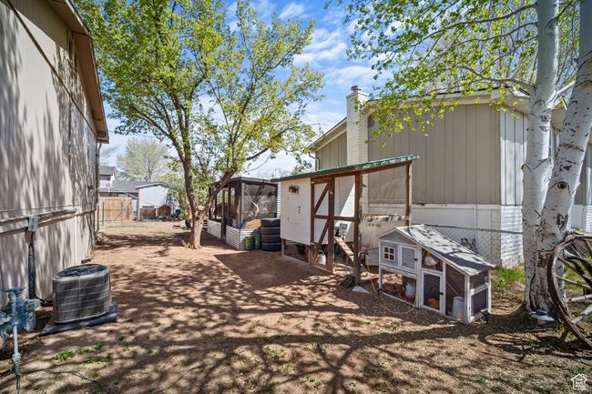 View of yard with a fenced backyard, exterior structure, an outbuilding, and central AC unit | Image 28