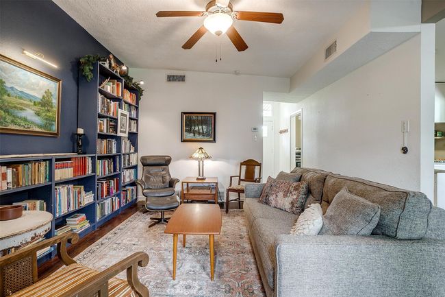 Living room with ceiling fan and wood finished floors | Image 7