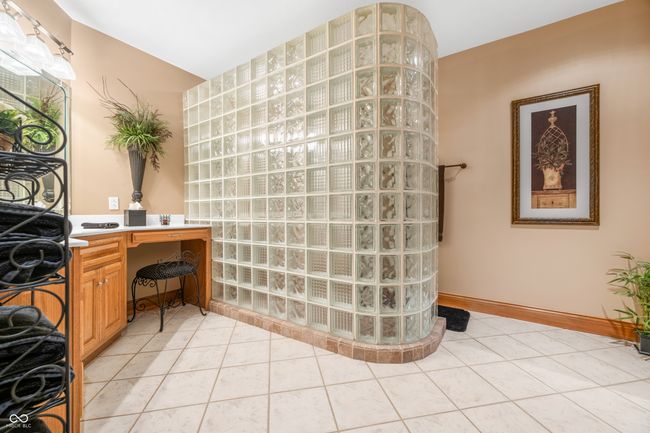 interior space featuring walk in shower, tile patterned flooring, and vanity | Image 98