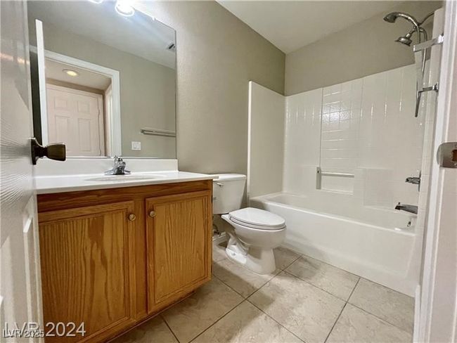 Bathroom with tile patterned floors, washtub / shower combination, toilet, and vanity | Image 16