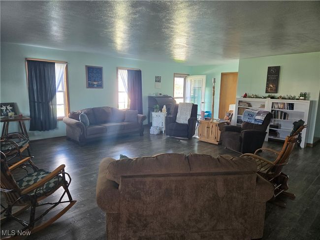 Living room with wood finished floors and a textured ceiling | Image 32