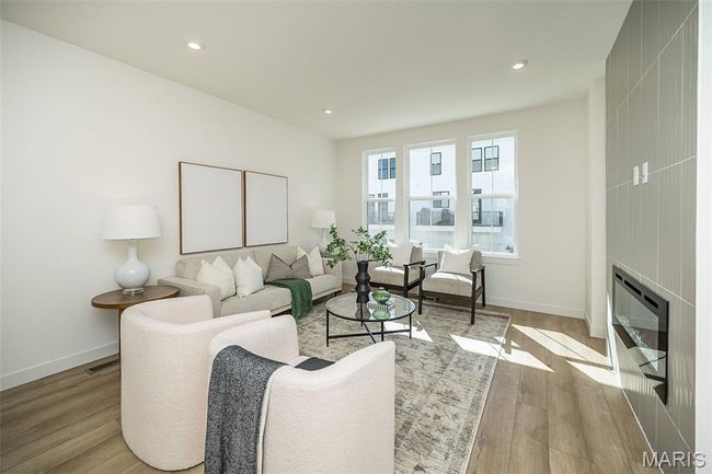 Living room with wood finished floors, recessed lighting, and heating unit | Image 13