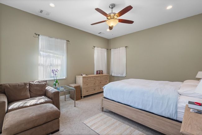 Carpeted bedroom featuring a ceiling fan, recessed lighting, and visible vents | Image 13