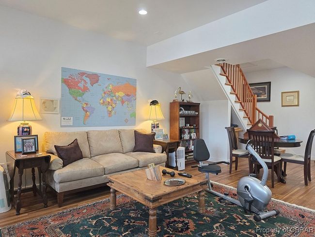Living area with wood finished floors, baseboards, recessed lighting, and stairs | Image 29