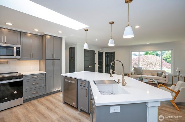 Plenty of elegant cabinets with a stunning backsplash, and under counter lights transform the space. | Image 10
