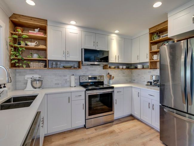 Kitchen featuring open shelves, stainless steel appliances, light countertops, and a sink | Image 8