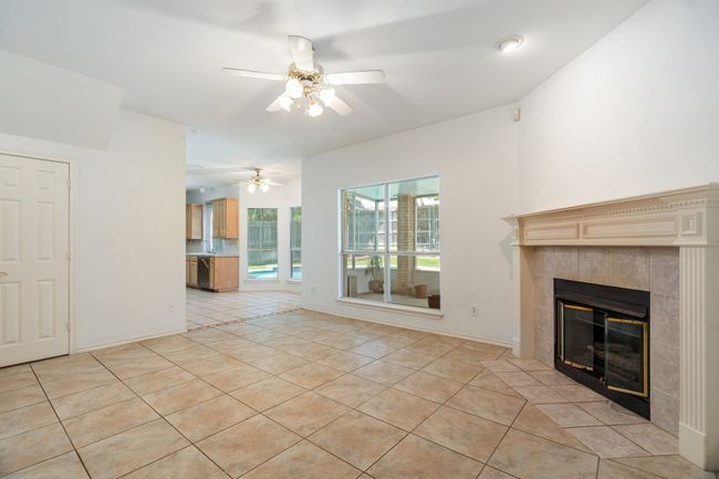 Unfurnished living room with light tile patterned floors, a tiled fireplace, and a ceiling fan | Image 35
