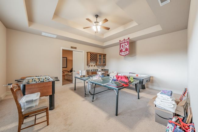 Game room with a raised ceiling, ceiling fan, and light colored carpet | Image 28